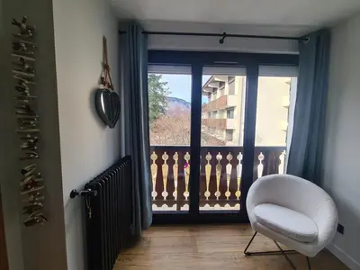 a white chair sitting in front of a window at Spacieux 2 pièces + cabine, idéal famille, 5 pers, centre village, proche commerces et pistes - FR-1-572-156 in Arâches-la-Frasse