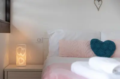 a bedroom with a bed with a heart pillow and a candle at Chalet Genepi - spectacular ski and summer home in Saint-Gervais-les-Bains