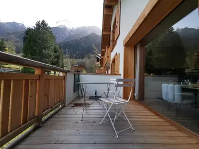 a patio with a table and chairs on a balcony at Terra Losa - Tout Nouveau - Centre des Houches - Point de Départ et D'arrivée TMB in Les Houches