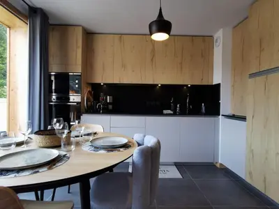 a kitchen with a wooden table with chairs and a dining room at Terra Losa - Tout Nouveau - Centre des Houches - Point de Départ et D'arrivée TMB in Les Houches
