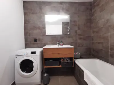 a bathroom with a washing machine and a sink and a tub at Terra Losa - Tout Nouveau - Centre des Houches - Point de Départ et D'arrivée TMB in Les Houches