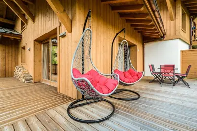 two hanging hammocks on a porch with chairs at Delys - Renovated - Beside Park - Climbing wall - Hikes - Mont-Blanc views in Les Houches
