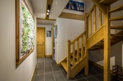 a hallway with a wooden staircase in a house at Delys - Renovated - Beside Park - Climbing wall - Hikes - Mont-Blanc views in Les Houches