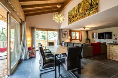 a dining room and living room with a table and chairs at Delys - Renovated - Beside Park - Climbing wall - Hikes - Mont-Blanc views in Les Houches