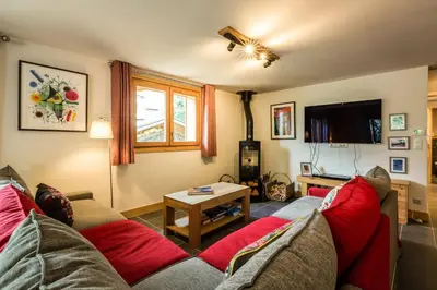 a living room with a couch and a table at Delys - Renovated - Beside Park - Climbing wall - Hikes - Mont-Blanc views in Les Houches