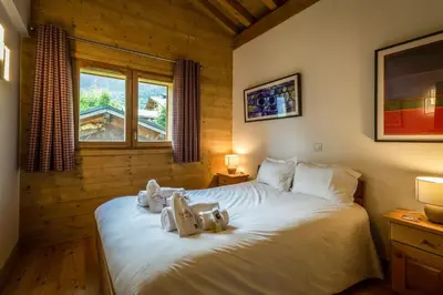 a bedroom with a bed with two teddy bears on it at Delys - Renovated - Beside Park - Climbing wall - Hikes - Mont-Blanc views in Les Houches
