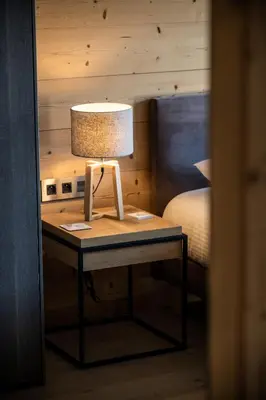 a lamp on a table next to a bed at Apartment Cortirion Megeve - by EMERALD STAY in Megève