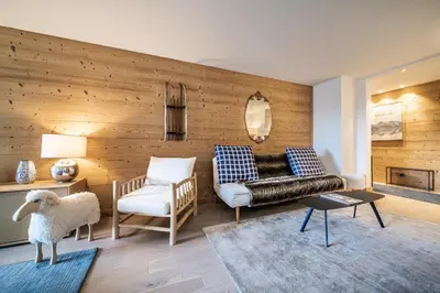 a living room with a couch and a chair at Apartment Cortirion Megeve - by EMERALD STAY in Megève