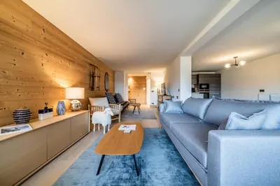 a living room with a blue couch and a table at Apartment Cortirion Megeve - by EMERALD STAY in Megève