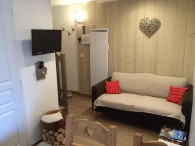 a living room with a couch and a heart on the wall at Appartement cosy à Morillon - 6 pers, internet - FR-1-815-90 in Morillon