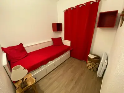 a room with a red bed in a attic at Appartement cosy à Morillon - 6 pers, internet - FR-1-815-90 in Morillon