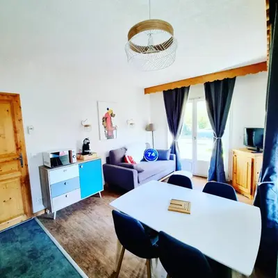 a living room with a table and chairs at Appartement avec piscine & jardin pied de la télécabine in Saint-Gervais-les-Bains