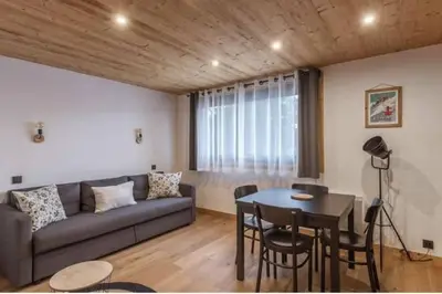 a living room with a couch and a table at Charmant T2 Megève, 10 min à pied du centre in Megève