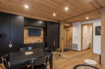 a dining room with black walls and a table and chairs at Charmant T2 Megève, 10 min à pied du centre in Megève