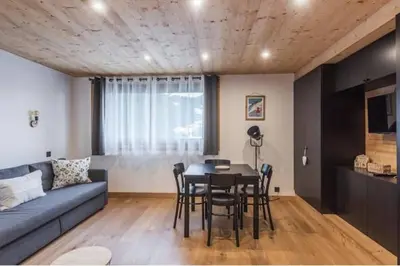 a living room with a couch and a table and chairs at Charmant T2 Megève, 10 min à pied du centre in Megève