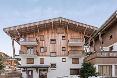an apartment building with wooden walls and balconies at Charmant T2 Megève, 10 min à pied du centre in Megève