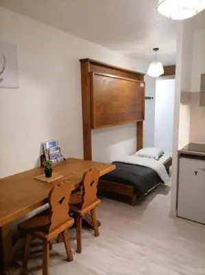a bedroom with a wooden table and a bed at Saint-Gervais, appart cosy, piscine & pied des pistes in Saint-Gervais-les-Bains