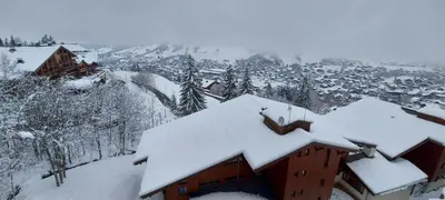 a snow covered roof of a building in a town at Lune D'Argent Appartement avec vue sur la montagne in Megève