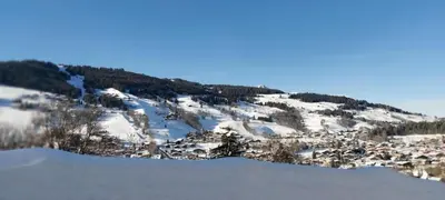 a snow covered mountain with a small town on it at Lune D'Argent Appartement avec vue sur la montagne in Megève
