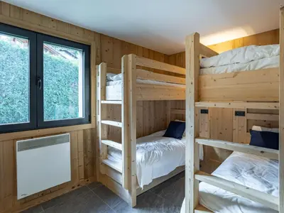 a bunk room with two bunk beds and a window at Holiday Home L'Adret by Interhome in Saint-Gervais-les-Bains