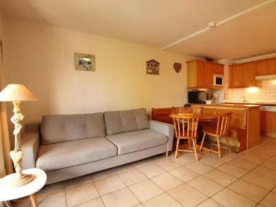 a living room with a couch and a kitchen at Studio cosy 4 pers avec parking, lave-vaisselle, balcon, proche des pistes et commerces - FR-1-572-56 in Arâches-la-Frasse