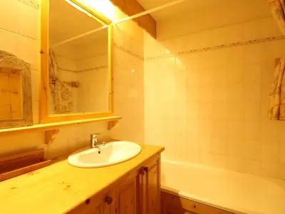 a bathroom with a sink and a mirror and a tub at Studio cosy 4 pers avec parking, lave-vaisselle, balcon, proche des pistes et commerces - FR-1-572-56 in Arâches-la-Frasse