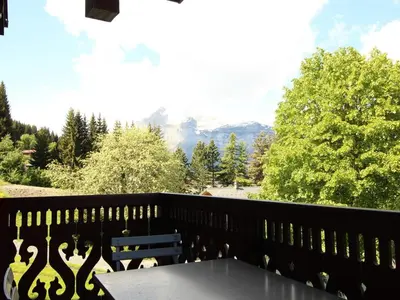 a table on a balcony with a view of mountains at Studio cosy 4 pers avec parking, lave-vaisselle, balcon, proche des pistes et commerces - FR-1-572-56 in Arâches-la-Frasse