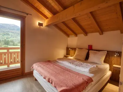 a bedroom with a bed and a large window at Appartement calme 2 chambres avec terrasse à Samoëns - FR-1-642-77 in Samoëns