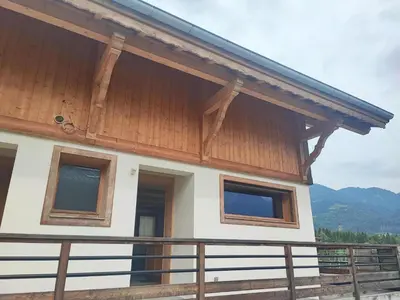 a house with a wooden roof and a balcony at Appartement calme 2 chambres avec terrasse à Samoëns - FR-1-642-77 in Samoëns