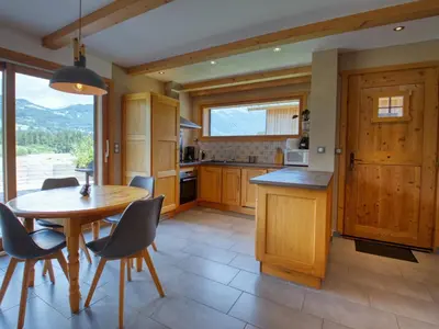 a large kitchen with wooden cabinets and a window at Appartement calme 2 chambres avec terrasse à Samoëns - FR-1-642-77 in Samoëns