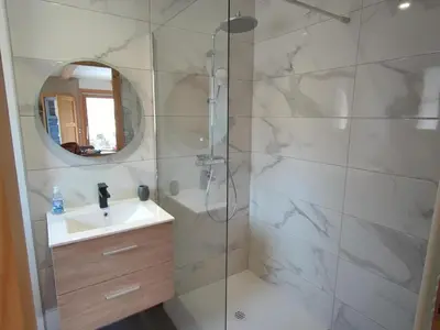 a bathroom with a shower with a sink and a mirror at Appartement calme 2 chambres avec terrasse à Samoëns - FR-1-642-77 in Samoëns