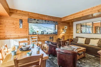 a living room with a table and a couch at Appartement Stenoga - Welkeys in Megève