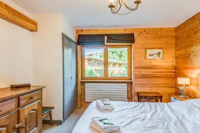 a bedroom with a bed and a desk and a window at Appartement Stenoga - Welkeys in Megève