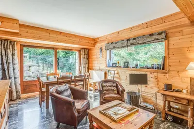 a living room with a table and chairs and a television at Appartement Stenoga - Welkeys in Megève