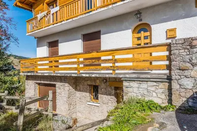 a house with a wooden balcony on top of it at Appartement Stenoga - Welkeys in Megève