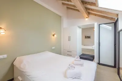a bedroom with a white bed and a mirror at Appartement Jorasses - Welkeys in Chamonix-Mont-Blanc