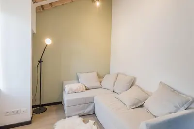 a living room with a white couch and a lamp at Appartement Jorasses - Welkeys in Chamonix-Mont-Blanc