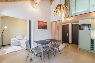 a kitchen and living room with a table and chairs at Appartement Jorasses - Welkeys in Chamonix-Mont-Blanc