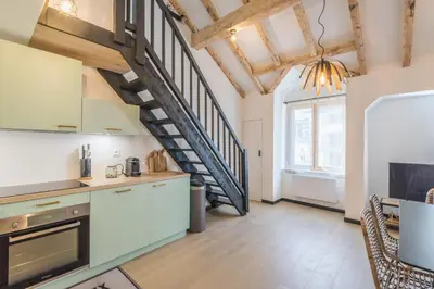 a kitchen with a spiral staircase in a loft at Appartement Jorasses - Welkeys in Chamonix-Mont-Blanc