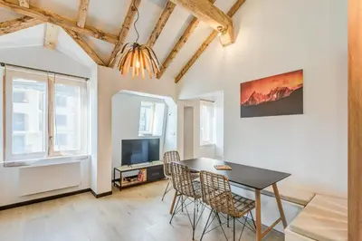 a dining room with a table and chairs and a tv at Appartement Jorasses - Welkeys in Chamonix-Mont-Blanc