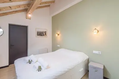 a bedroom with a bed with white sheets and towels at Appartement Jorasses - Welkeys in Chamonix-Mont-Blanc