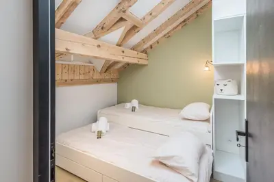 two beds in a room with wooden ceilings at Appartement Jorasses - Welkeys in Chamonix-Mont-Blanc