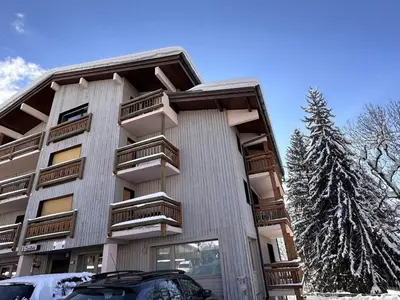 a building with balconies and a car parked in front of it at Studio 4 pers. avec Balcon, Proche Pistes et Commerces, Parking Inclus - Arâches-la-Frasse - FR-1-572-181 in Arâches-la-Frasse