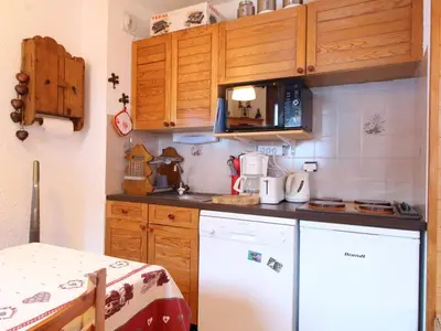 a kitchen with a white refrigerator and wooden cabinets at Studio 4 pers. avec Balcon, Proche Pistes et Commerces, Parking Inclus - Arâches-la-Frasse - FR-1-572-181 in Arâches-la-Frasse