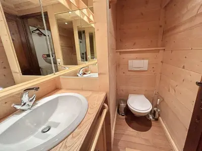 a bathroom with a sink and a toilet and a mirror at Charmant 2 pièces, 4 couchages, Megève - À 400m des remontées mécaniques, balcon et parking inclus - FR-1-597-169 in Megève