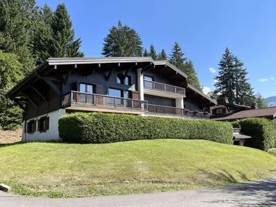 a house on a hill with hedges in front of it at Charmant 2 pièces, 4 couchages, Megève - À 400m des remontées mécaniques, balcon et parking inclus - FR-1-597-169 in Megève