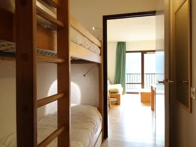 a bedroom with bunk beds with a door open at Studio pour 5 personnes avec balcon, proche des pistes et commerces - Résidence Andromède, Flaine Forêt - FR-1-687-93 in Arâches-la-Frasse