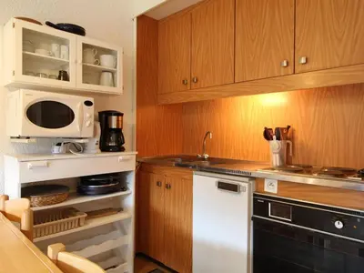 a kitchen with wooden cabinets and a white microwave at Studio pour 5 personnes avec balcon, proche des pistes et commerces - Résidence Andromède, Flaine Forêt - FR-1-687-93 in Arâches-la-Frasse