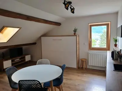 a dining room with a white table and chairs at Nid douillet proche des pistes avec vue montagne in Saint-Gervais-les-Bains