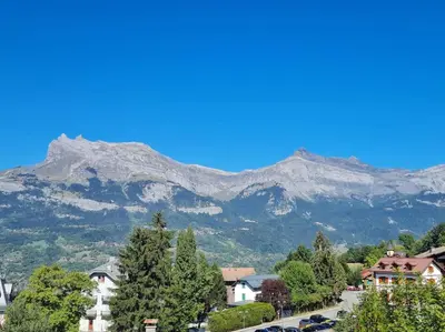 a mountain in the distance with a town and trees at Nid douillet proche des pistes avec vue montagne in Saint-Gervais-les-Bains